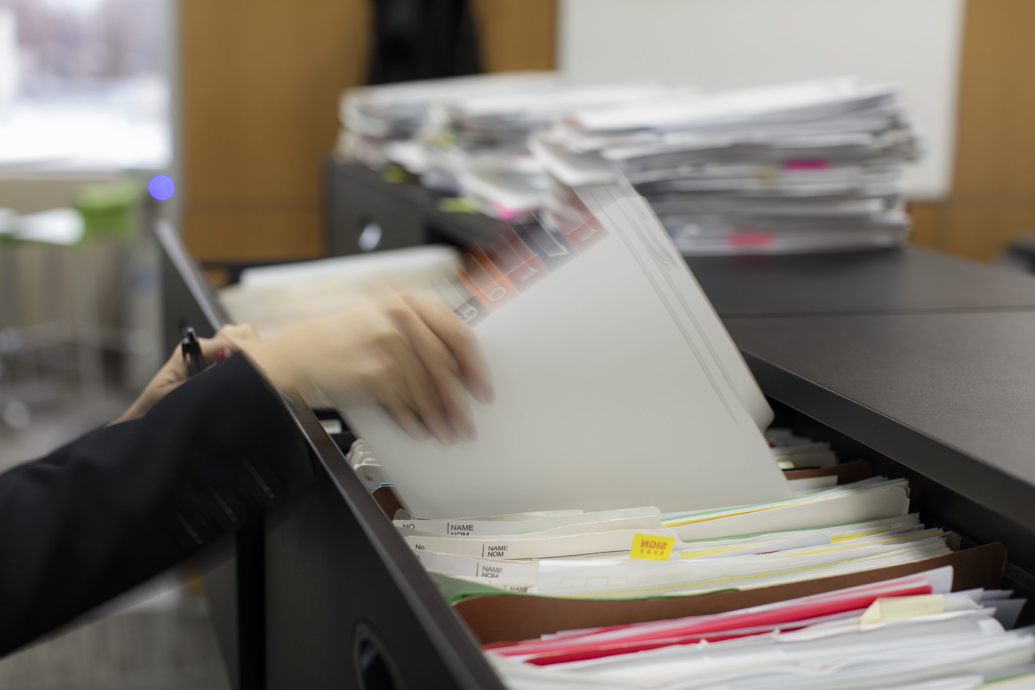 woman filing papers in a cabinet; highlighting employment law