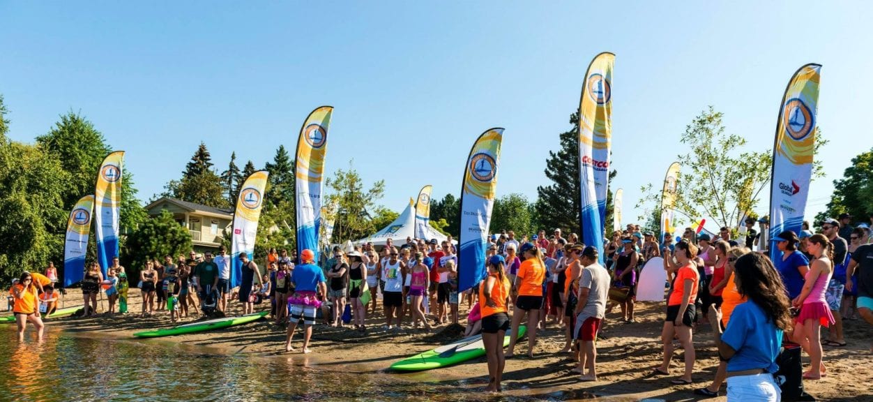 Pihl Law Paddle for Prevention Beach with signs and paddlers