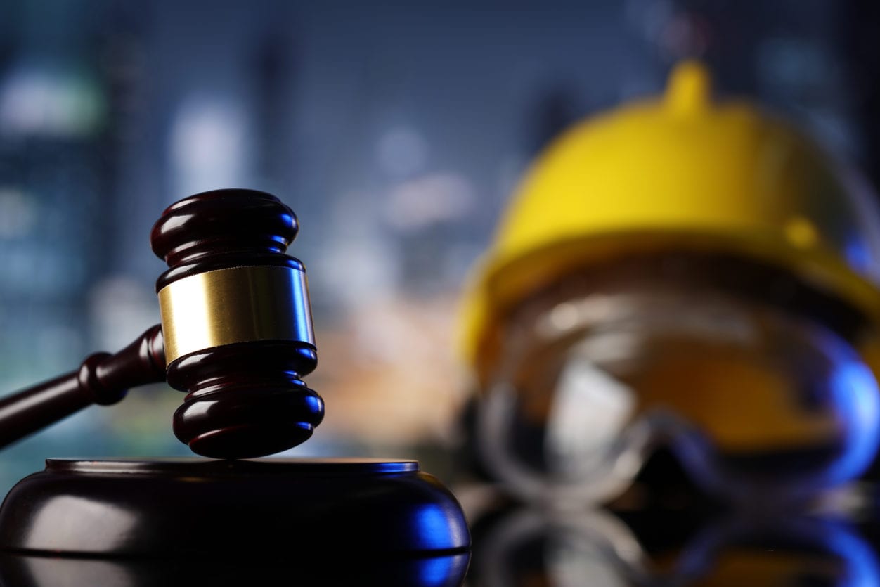 Construction hard hat and goggle with a judges mallet highlighting construction law, contract disputes, projects and progressive release