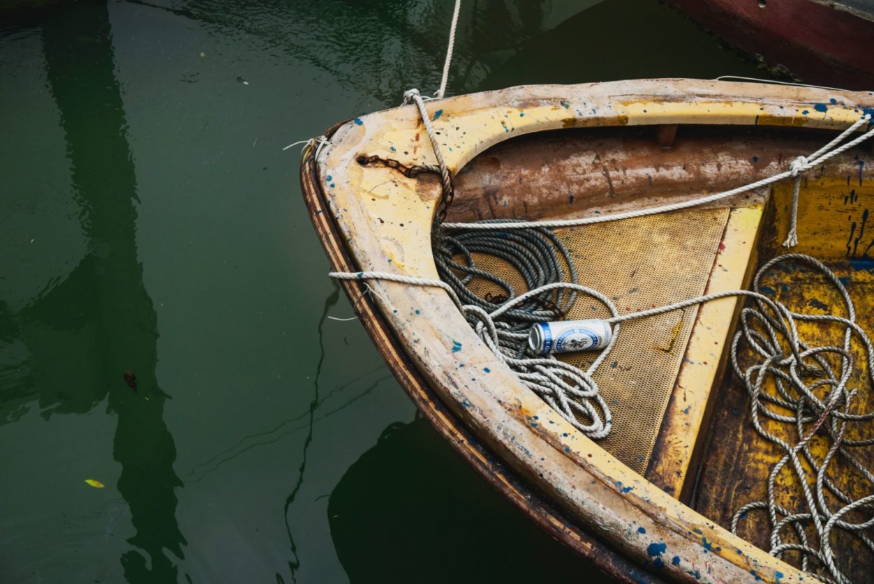 a birds eye view of the front of an old fishing boat that's being moored in a lake