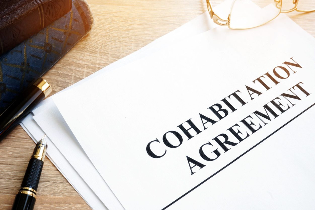 A Cohabitation Agreement (also known as a Marriage Agreement) document and books on a table.