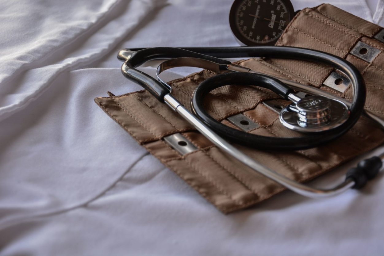 a black and silver stethoscope lying on a leather pouch